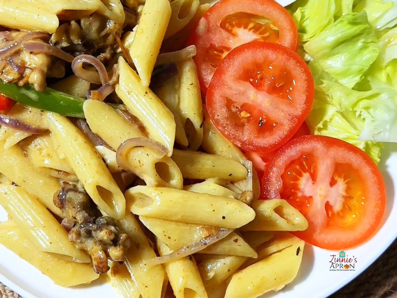 Creamy-chicken-pasta-served-in-white-plate-with-cabbage-egg-and-tomato
