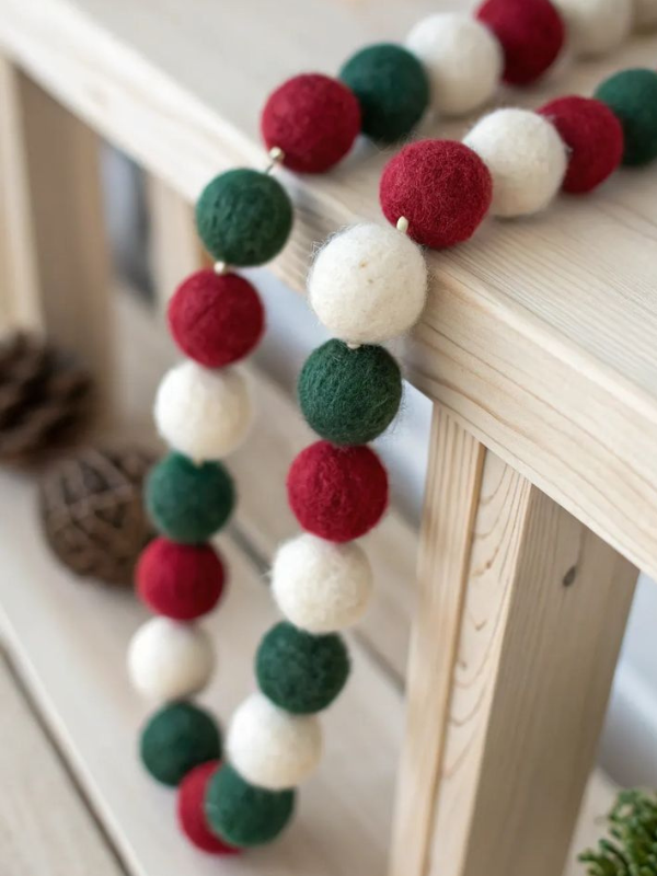 Fun and colorful felt ball garland strung on twine, ideal for crafty Christmas decorating