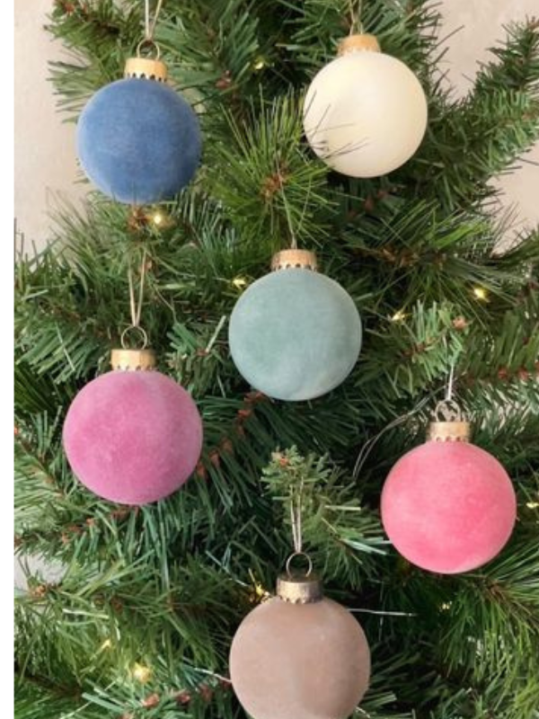 Clear Christmas ornaments with snowy flocking and pine accents for a wintery holiday look as one of diy christmas crafts
