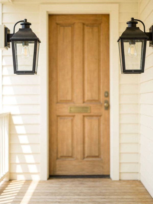 A -small- front -porch -with- two -matching- lanterns placed -symmetrically -on -either -side -of- the -door, -identical in size and style, nothing -else -on -the- floor